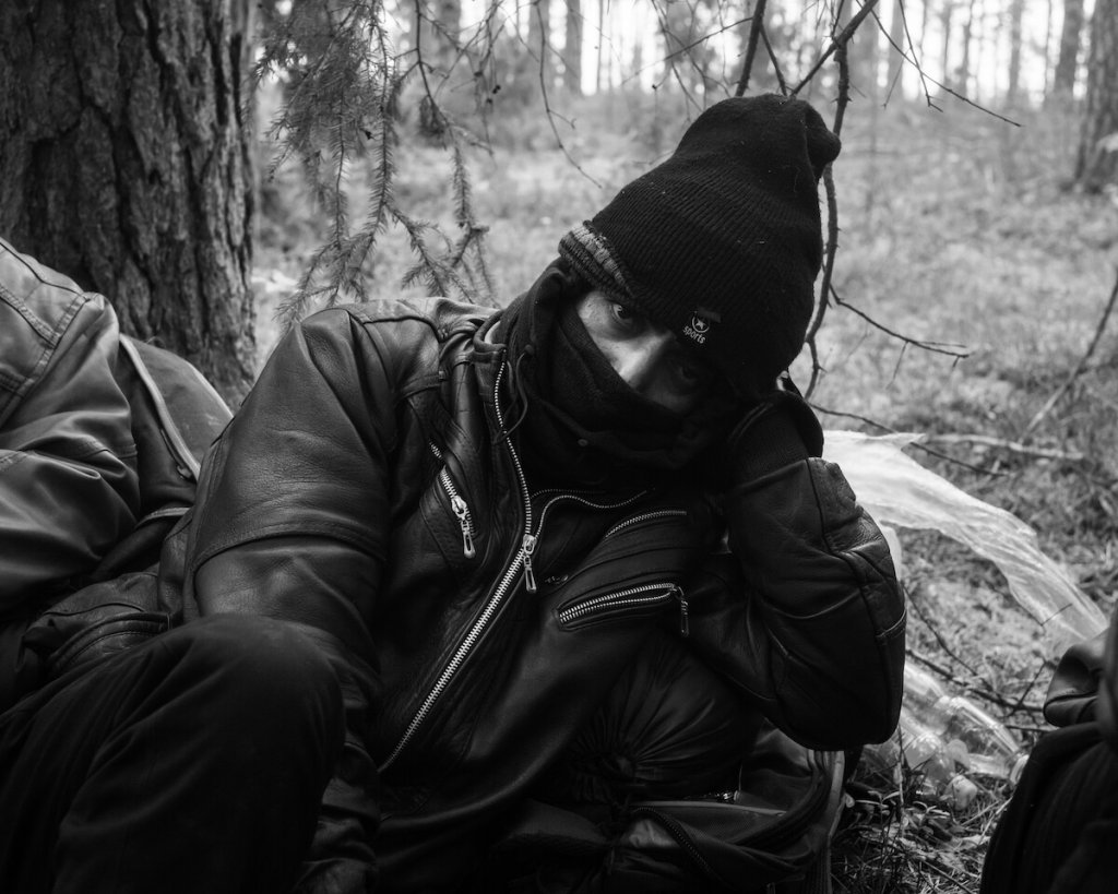 Zdjęcie Karola Grygoruka z migrantami w lesie na polsko-białoruskiej granicy.