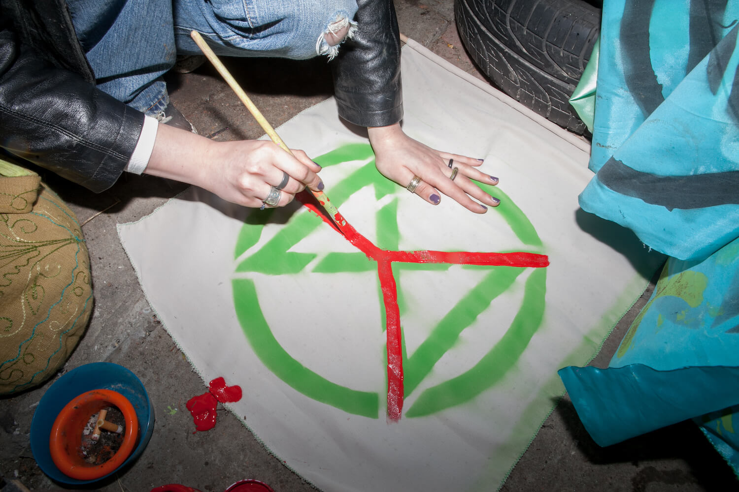 Aktywiści malują logo Extinction Rebellion.