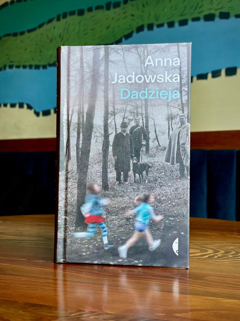 Okładka książki „Dadzieja”, autorka: Anna Jadowska, wydawnictwo Czarne; czarno-białe zdjęcie osób w lesie oraz biegnące dzieci.