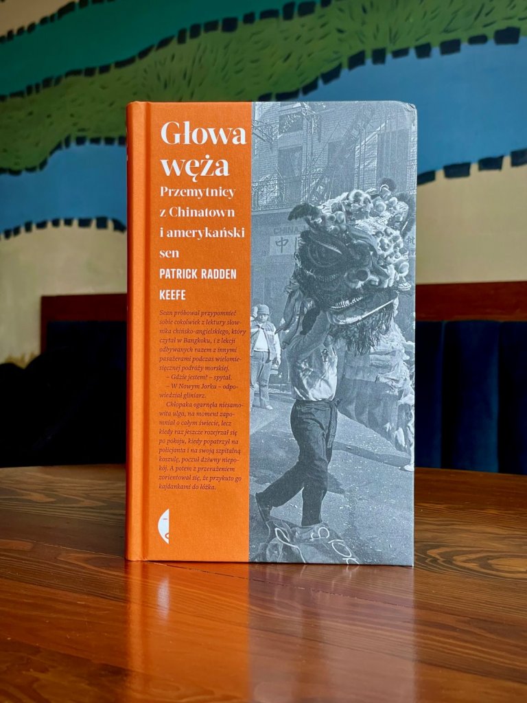 Okładka książki „Głowa węża. Przemytnicy z Chinatown i amerykański sen”, autor: Patrick Radden Keefe, wydawnictwo Czarne; zdjęcie postaci w kostiumie smoka.